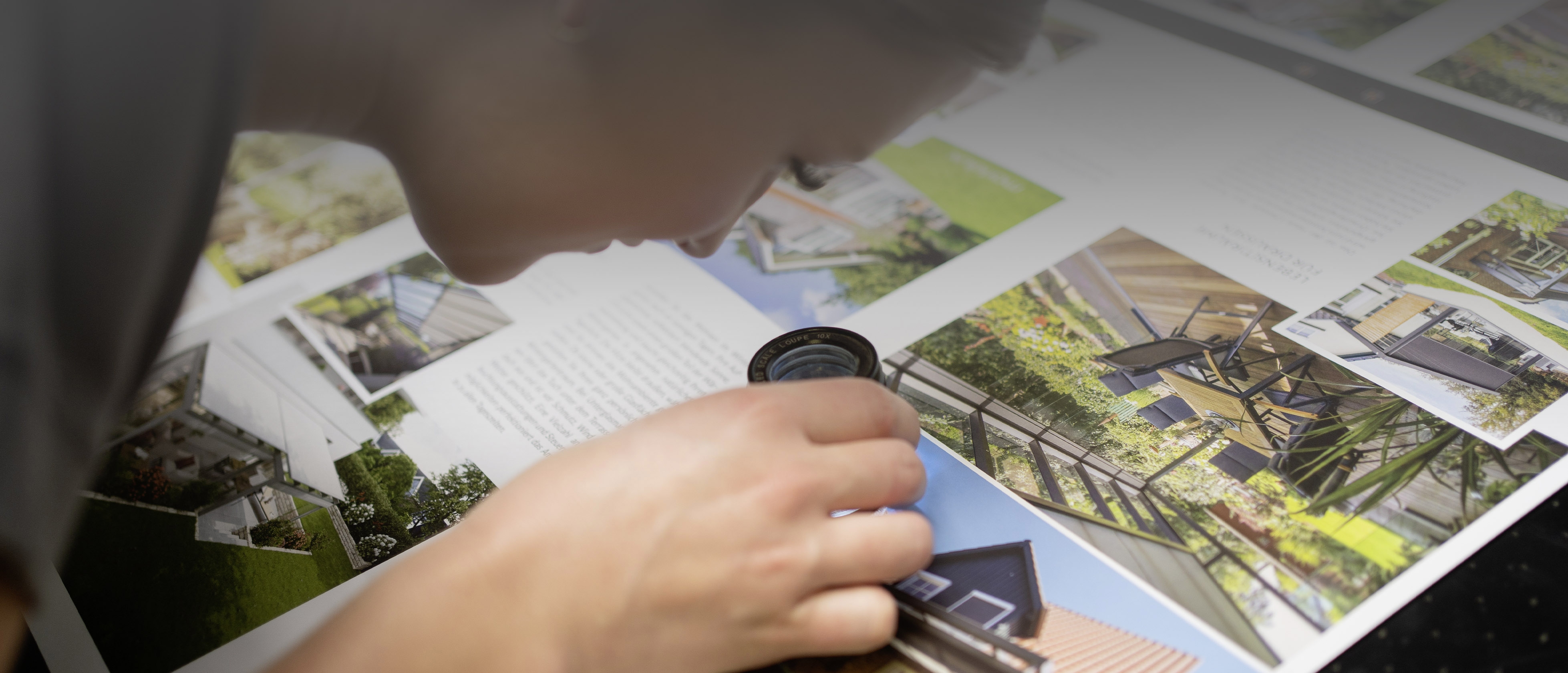 Druckerin überprüft Druckereierzeugnisse mit Speziallupe