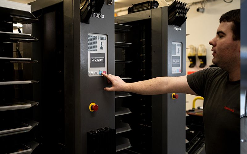 Weiterverarbeitung in der Druckerei Rosebrock in Sottrum - Mitarbeiter an Falzmaschine